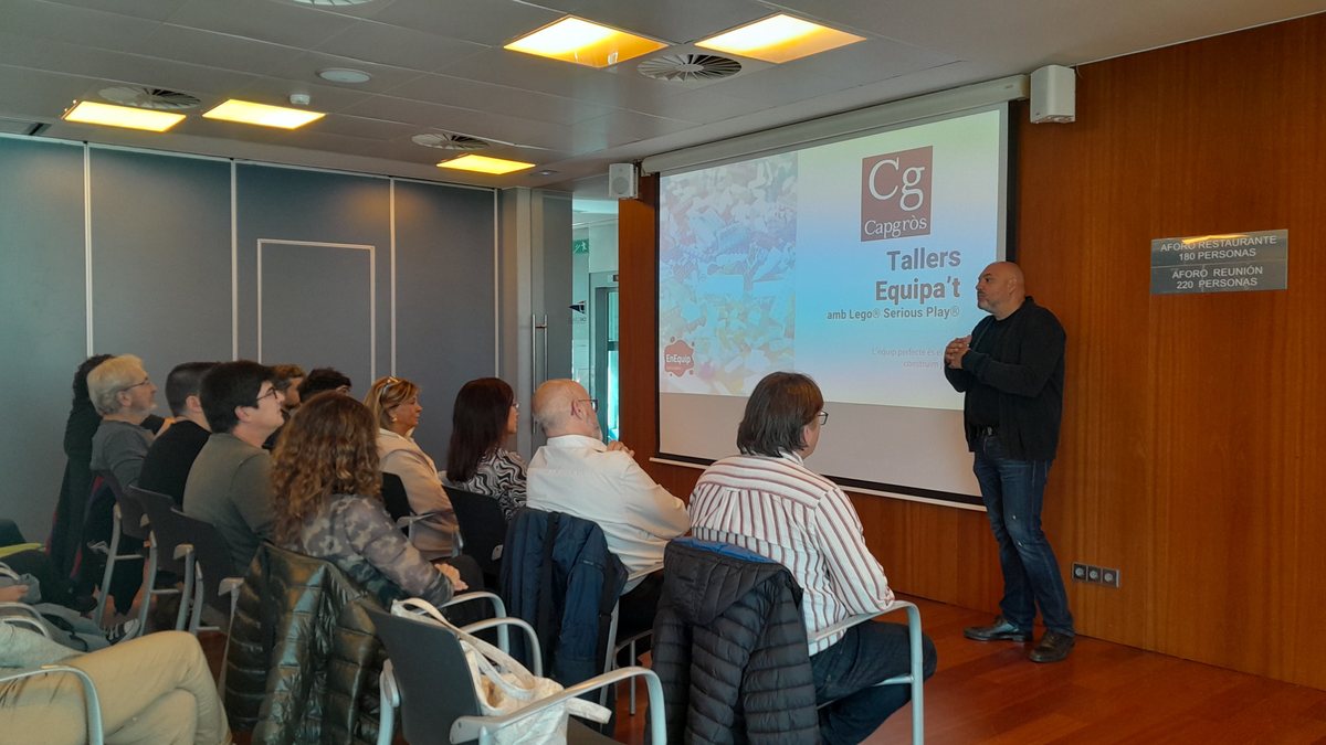 Federic de Gracia abre una sesión ante un grupo sentado frente a la pantalla de presentación